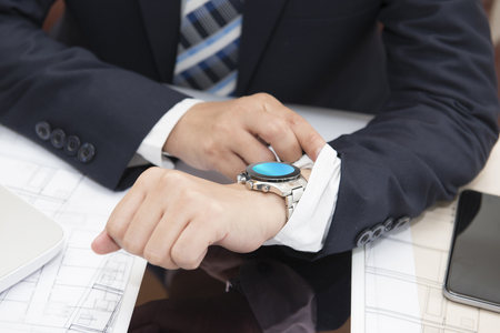 A businessman looking at his watch.  Clipping path on watchの写真素材