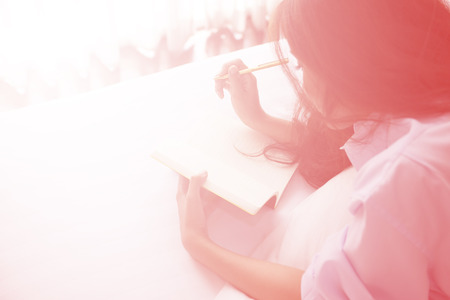 Beautiful woman reading a diary in the bedroom. Digital art for backgroundの写真素材