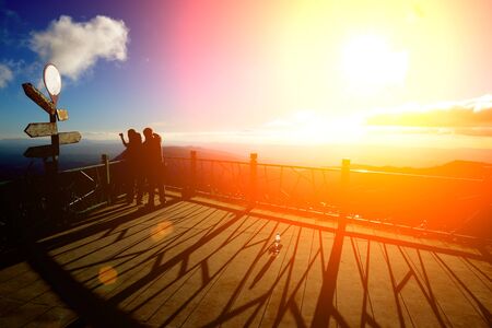 Silhouettes of family happy holiday. Views of mountains, clouds and sun.の写真素材
