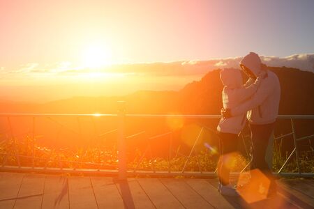 Silhouette of couples happy at scenic mountain fog and sun.の写真素材