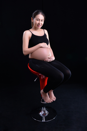 Pregnant woman on a black backgroundの写真素材