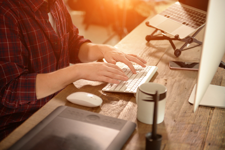 A young man working on a computer in their home.の写真素材