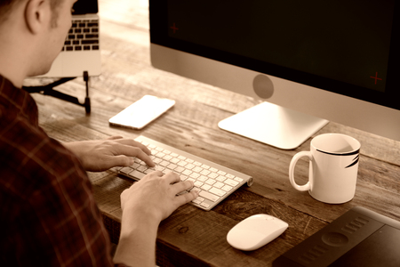 A young man working on a computer in their home.の写真素材