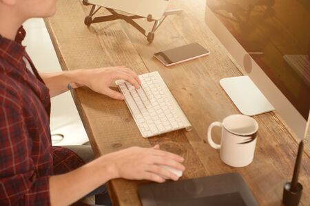 A young man working on a computer in their home.の写真素材