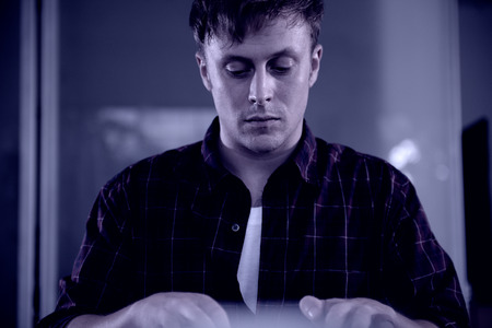 A young man working on a computer in their home.の写真素材