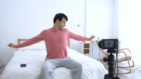 Handsome man use vlogging (video blogging) to share everything pop culture to DIY Projects, gaining millions of followers of diverse backgrounds.の写真素材