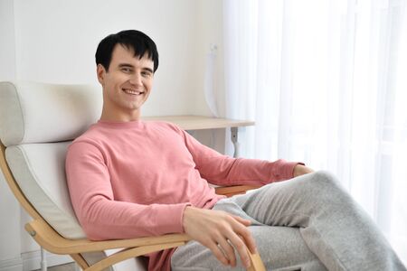 Handsome man sitting comfortably in his private bedroom.の写真素材