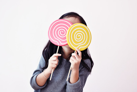 Little girl is enjoying candy. Parents just need to be careful about oral health.の写真素材