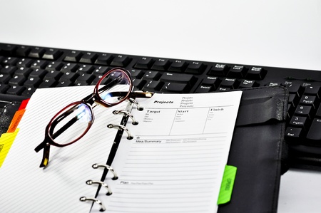 project note,glasses and keyboard with white backgroundの写真素材