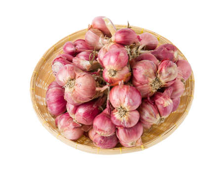 shallots on a wicker basket on a white backgroundの写真素材