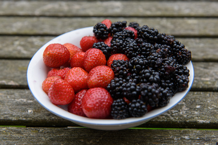 Bowl full of strawberries and blackberriesの写真素材
