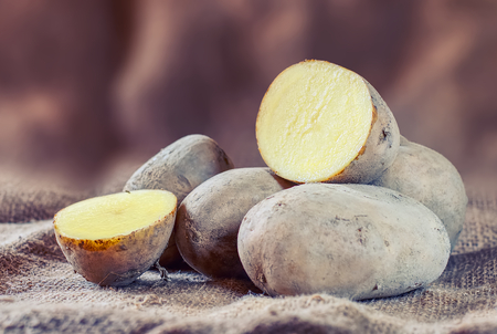 New raw potatoes on a rustic background.の写真素材
