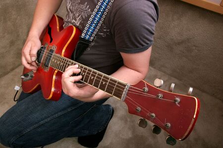 hand of guitarist playing at red electric guitarの写真素材
