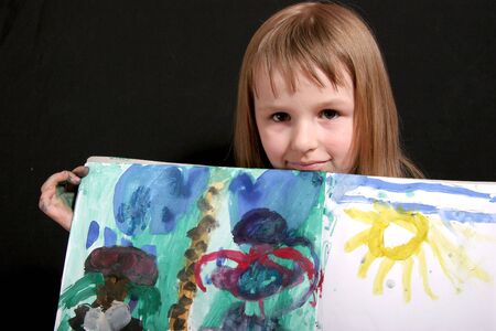 little girl show her gouache art with yellow sunの写真素材