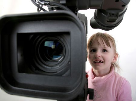 the little girl in pink dress look to the finder of dv-camcorderの写真素材