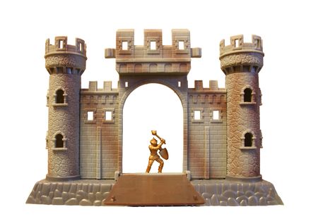 isolated plastic toy castle with brave toy knight-guardian in frontの写真素材