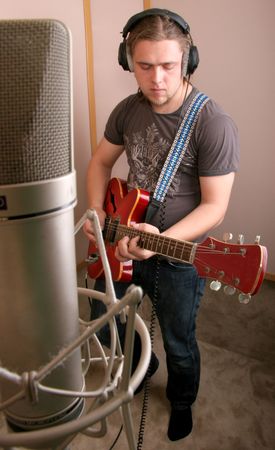 guitarist play in isolated studio with chrome microphone on crab support in front viewの写真素材