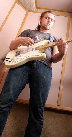 guitarman playing on red electric guitar in isolated audio studioの写真素材