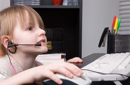 small girl with headphone and microphone work with computer mouse