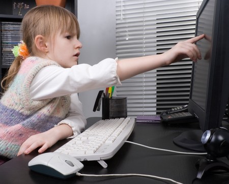 little girl touch the computer monitorの写真素材