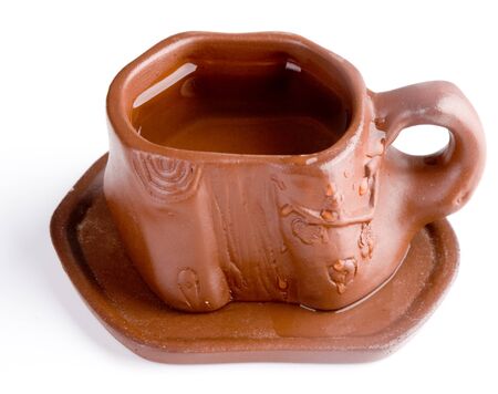 isolated clay cup with hot tea on saucerの写真素材