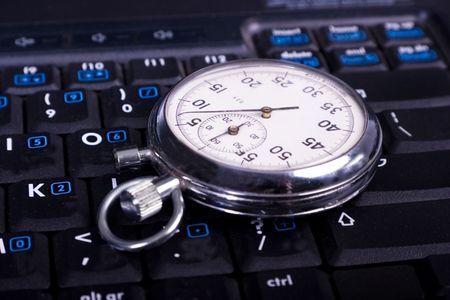 close-up stop-watch laying down the laptop kayboardの写真素材