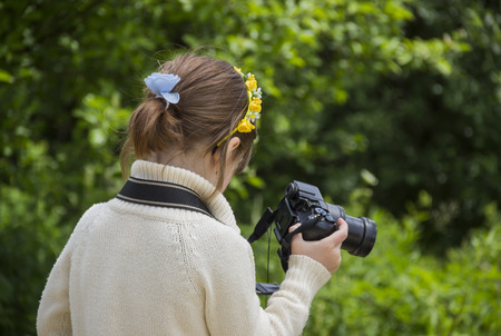 little girl shooting with big photo camera