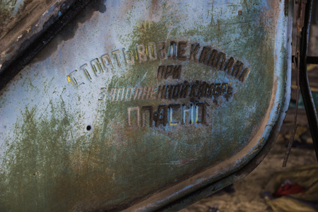 close-up details of old rusty combine harvester with warning inscriptionの写真素材