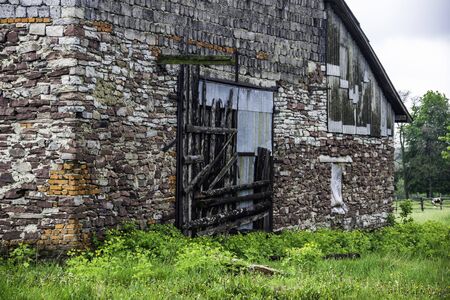 close-up of the gate of big abandoned brick barn in countrysideの写真素材