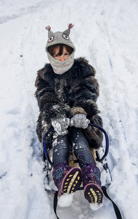close-up of little girl sitting on the sledgeの写真素材