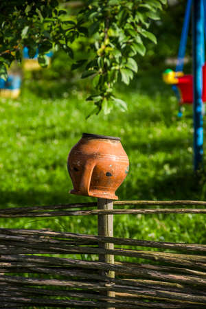 a traditional ukrainian jug on the wooden fenceの写真素材