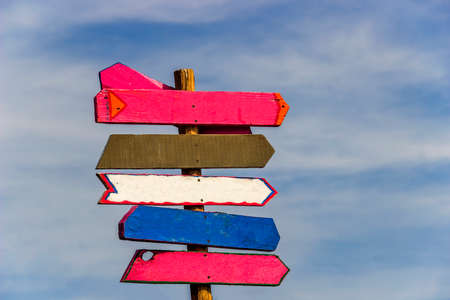 close-up of post with multiple arrows as tourist information signの写真素材