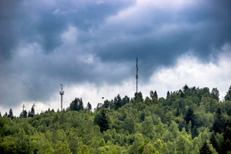 a telecommunication tower and flagpole with ukrainian flag at the Carpathian mountains, Skole...