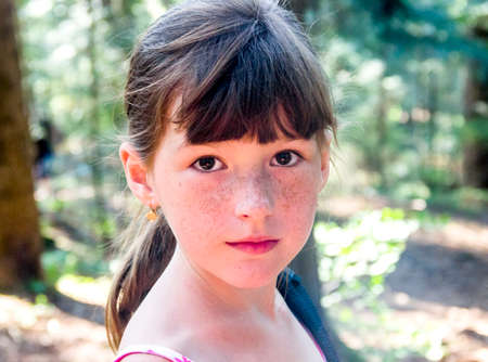close-up of a portrait of little girl in spruce forest