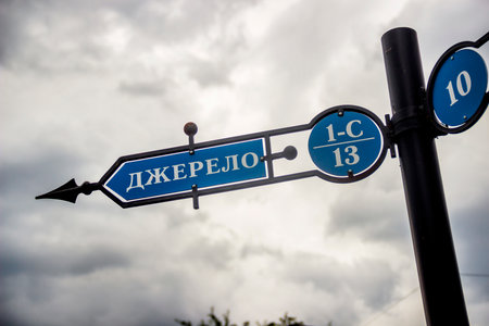 close-up of post with information arrows to the sources of mineral-healing water into the Carpathian, Shidnitca, Lviv region of Ukraine. Text translated from Ukrainian as 'source'の写真素材