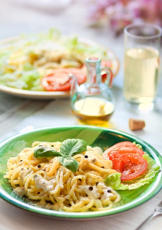 Fresh pasta with pepper sauce and saladの写真素材