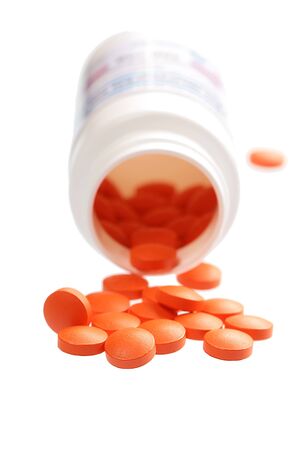 Open a bottle of spilled pills. Isolated on white background の写真素材