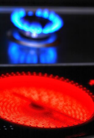 Red hot ceramic stove electric cooker and blue flames of gas stove の写真素材