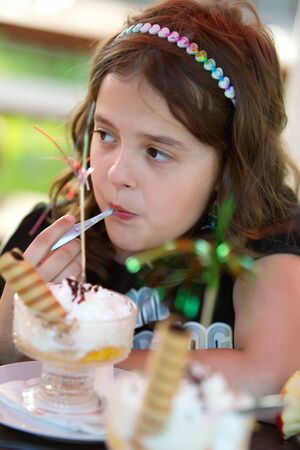 Young girl eating the fruit cupの写真素材