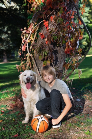  Little boy in the park with a golden retriever dog の写真素材