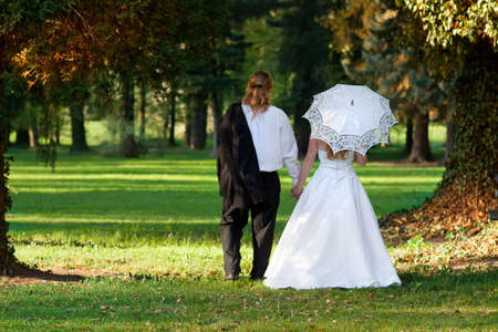 newlyweds in the park with umbrellaの写真素材