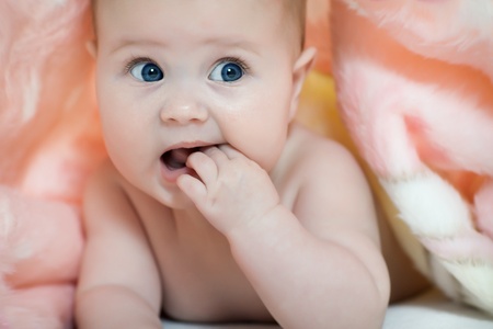 Charming baby. Beautiful baby under pink towel の写真素材