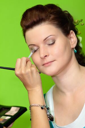 Young happy beautiful woman with makeup brushの写真素材
