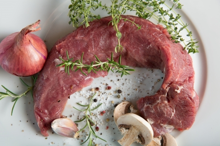 Pork mea  - Tenderloin on a plate with spices and herbsの写真素材