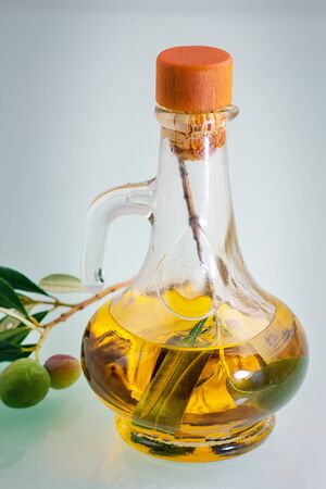 bottle of olive oil on old wooden table and an olive branchの写真素材