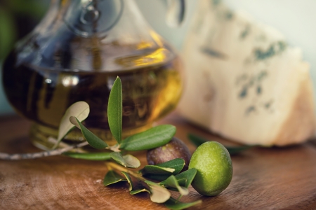 bottle of olive oil on old wooden table and an olive branchの写真素材