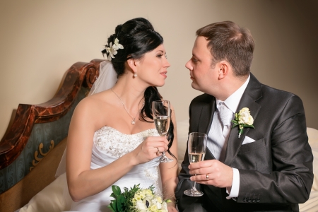 Portrait of the newlyweds on studio shooting with glasses of champagne の写真素材