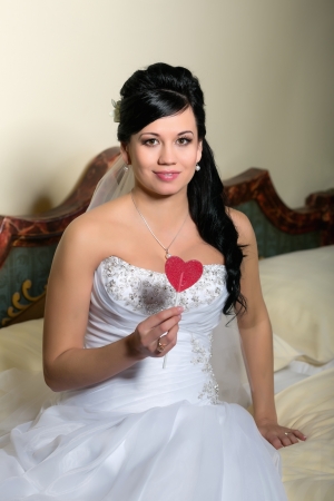 Portrait of a young bride with a heart-shaped candy の写真素材