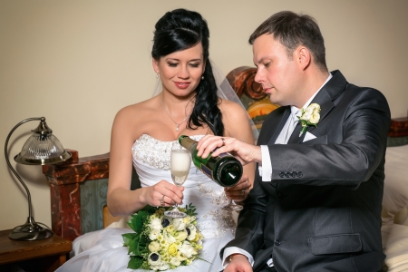 Portrait of the newlyweds on studio shooting with glasses of champagne の写真素材