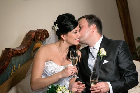Portrait of the newlyweds on studio shooting with glasses of champagne の写真素材
